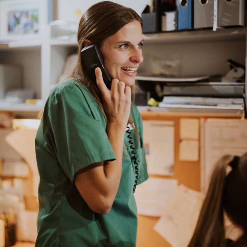 Pflegekraft spricht am Telefon.